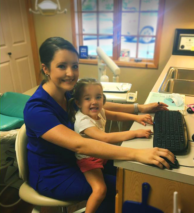 Bhargava Dental Assistant with a young girl on her lap at the dentist office